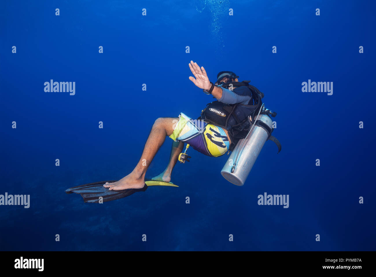 Underwater surfing. Scuba diver embarked on fins and rides them in