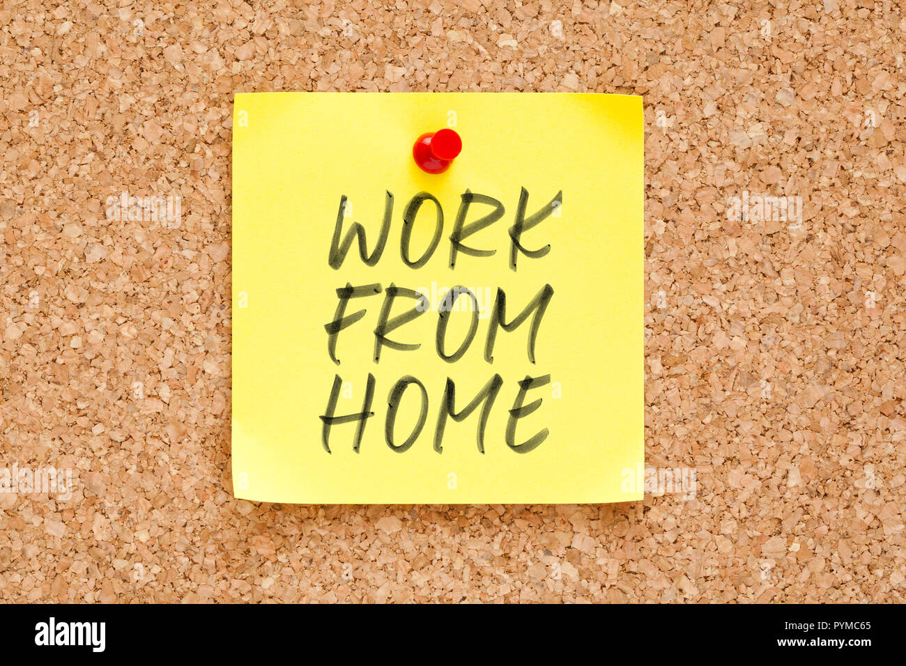 Text work from home handwritten on yellow sticky note pinned on cork