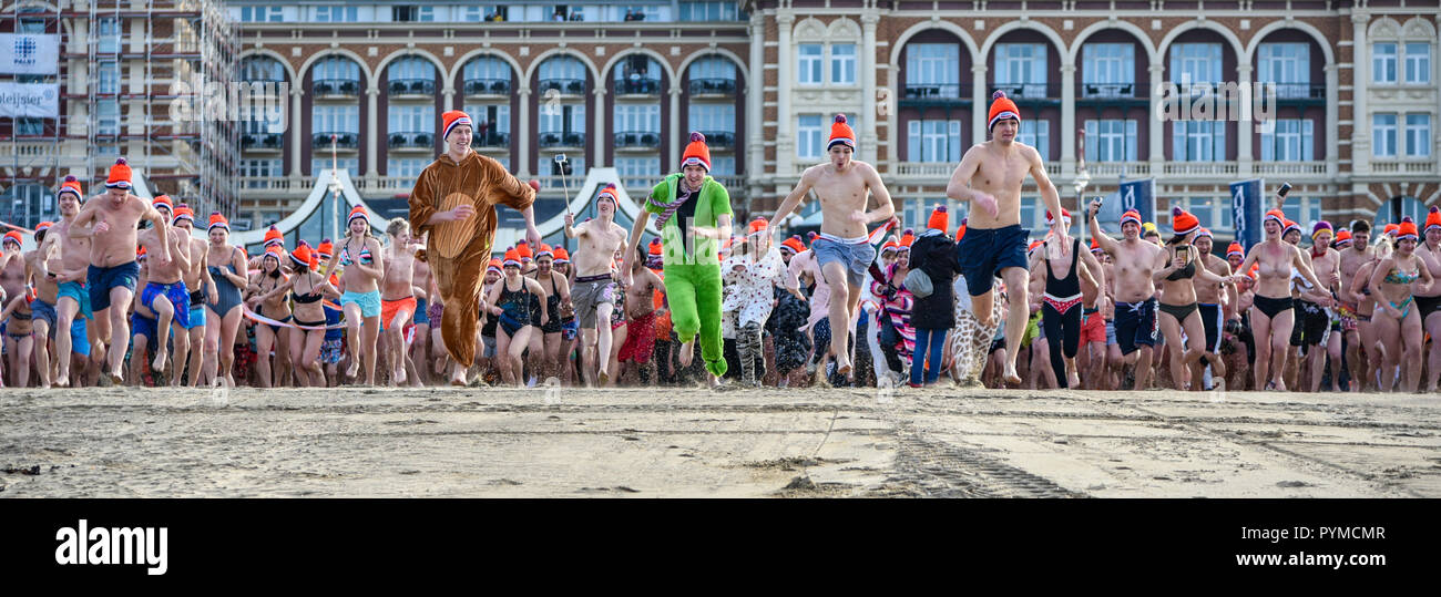 SCHEVENINGEN, 1 January 2018 - Group of friends returning to the changing room after having accomplished the new year dive in a frozen North Sea water Stock Photo