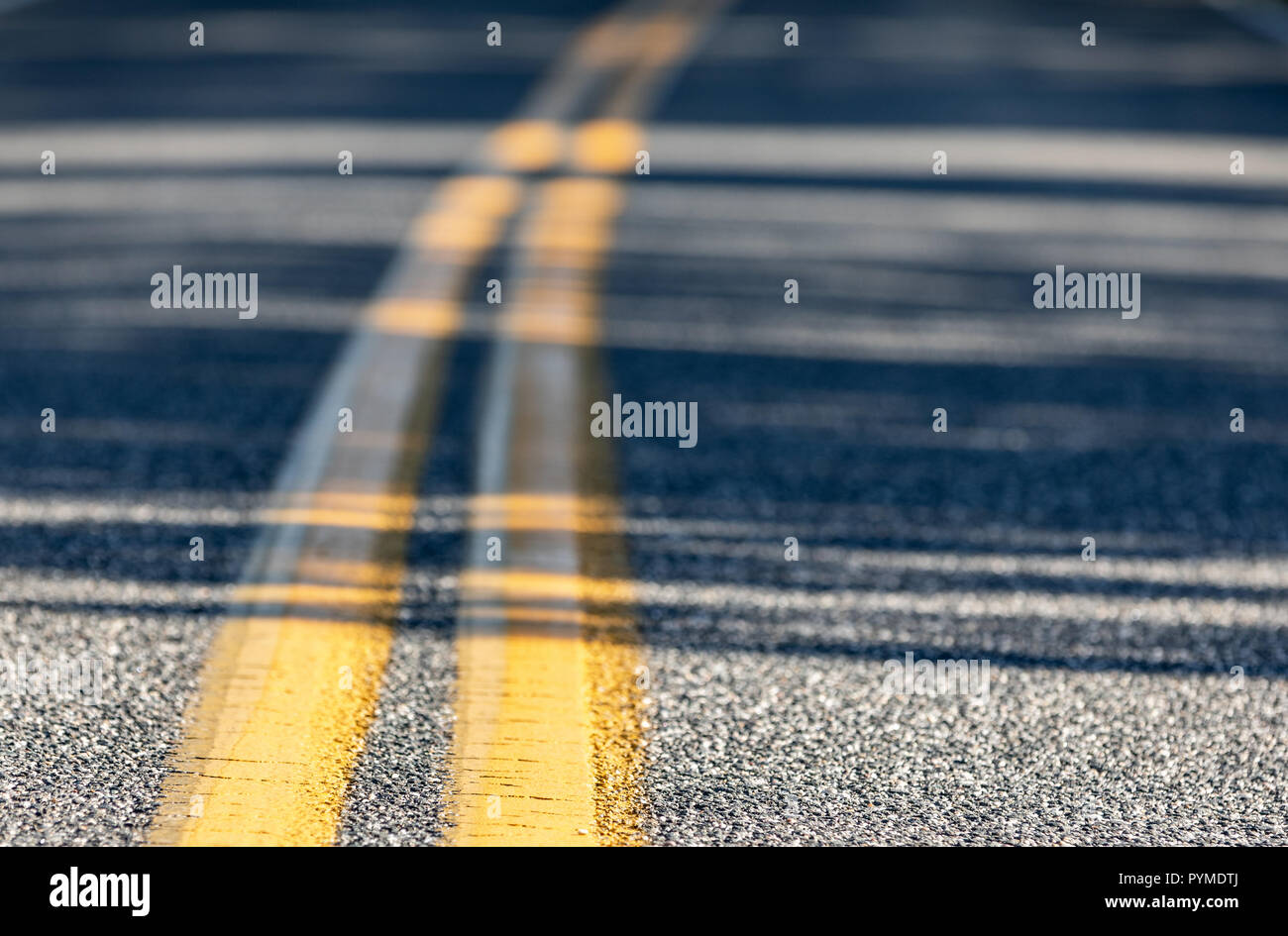 close up of a double yellow line on a asphalt road Stock Photo