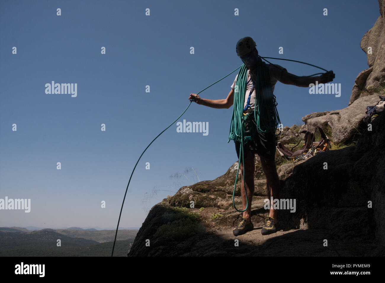 Back lit view of climber coiling a climbing rope Stock Photo Alamy
