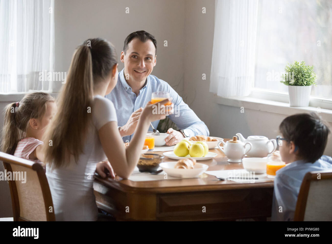 Happy family with kids having breakfast at home Stock Photo