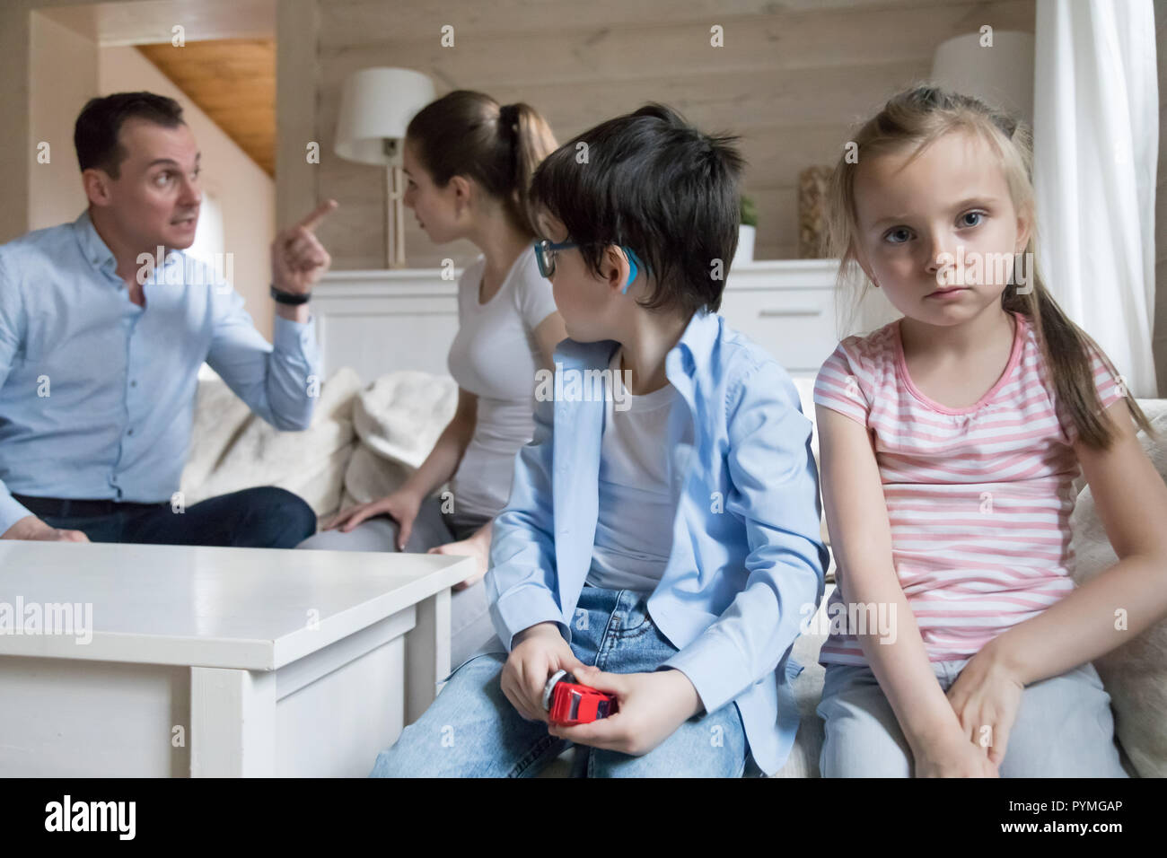 Couple with little preschool daughter and son at home quarrellin Stock Photo