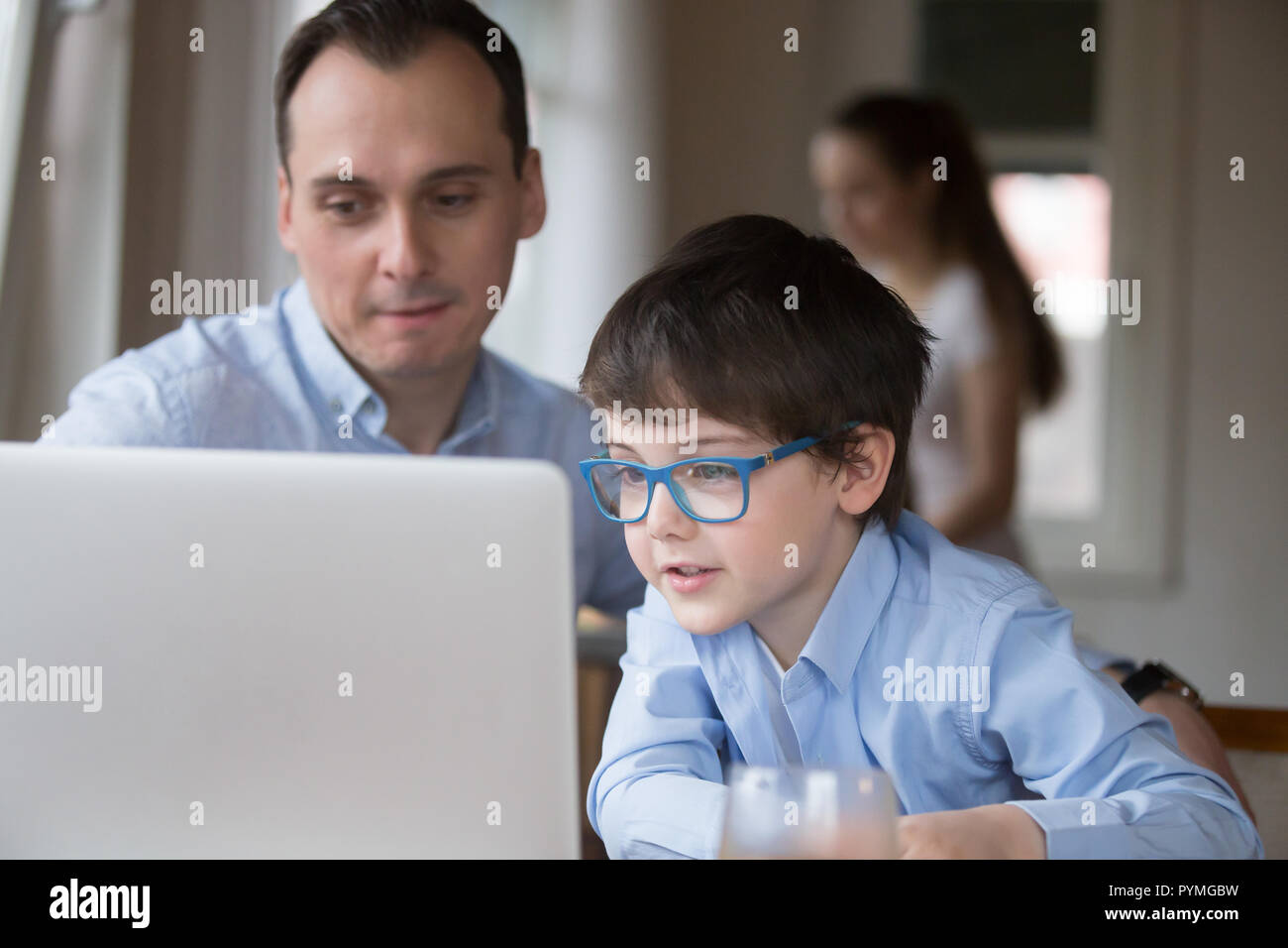 Father and son using laptop sitting at home Stock Photo - Alamy