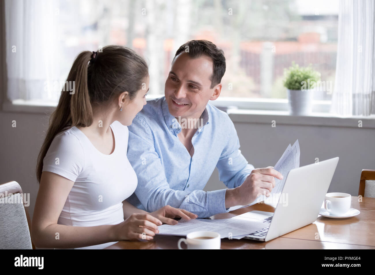 Happy wife and husband checking bills at home Stock Photo