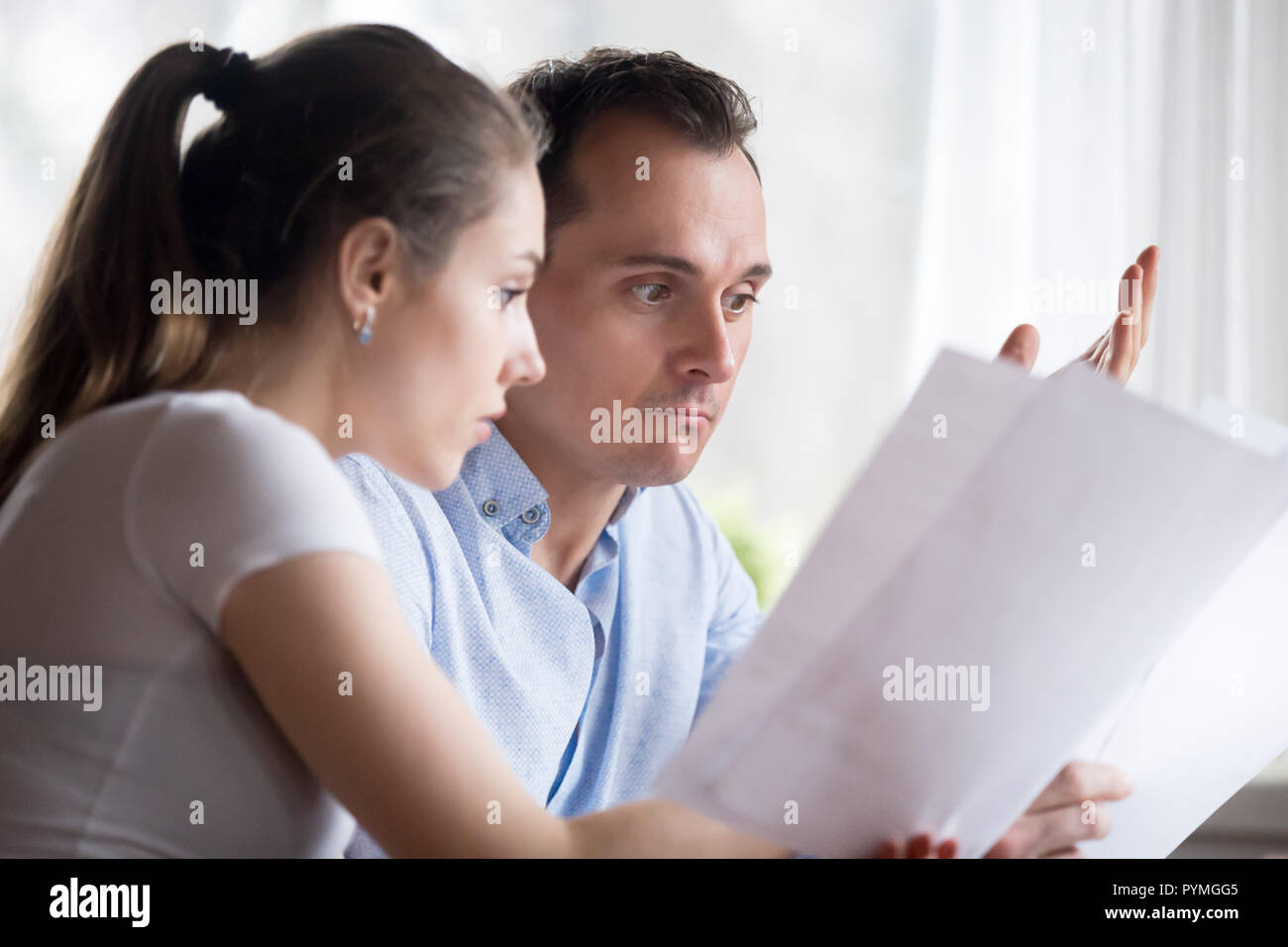Close up spouses reading letter feels confused Stock Photo