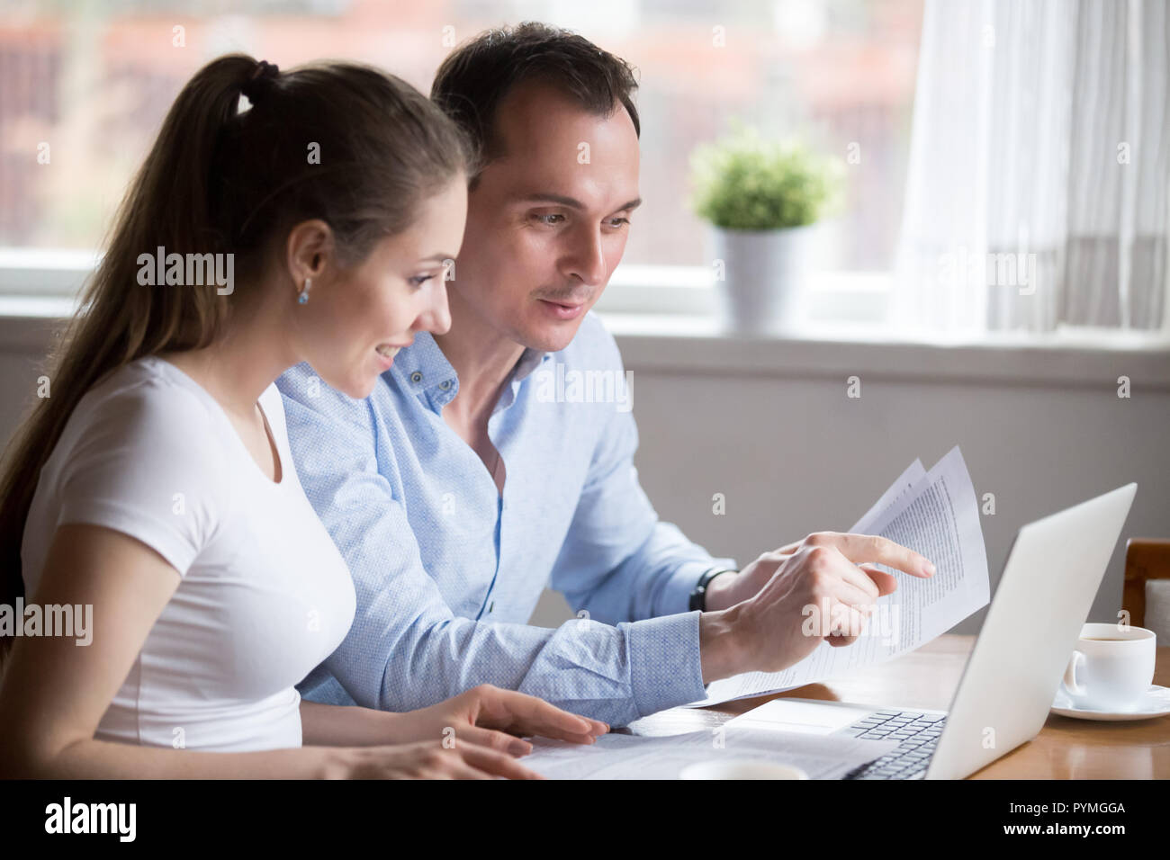 Satisfied wife and husband checking bills at home Stock Photo