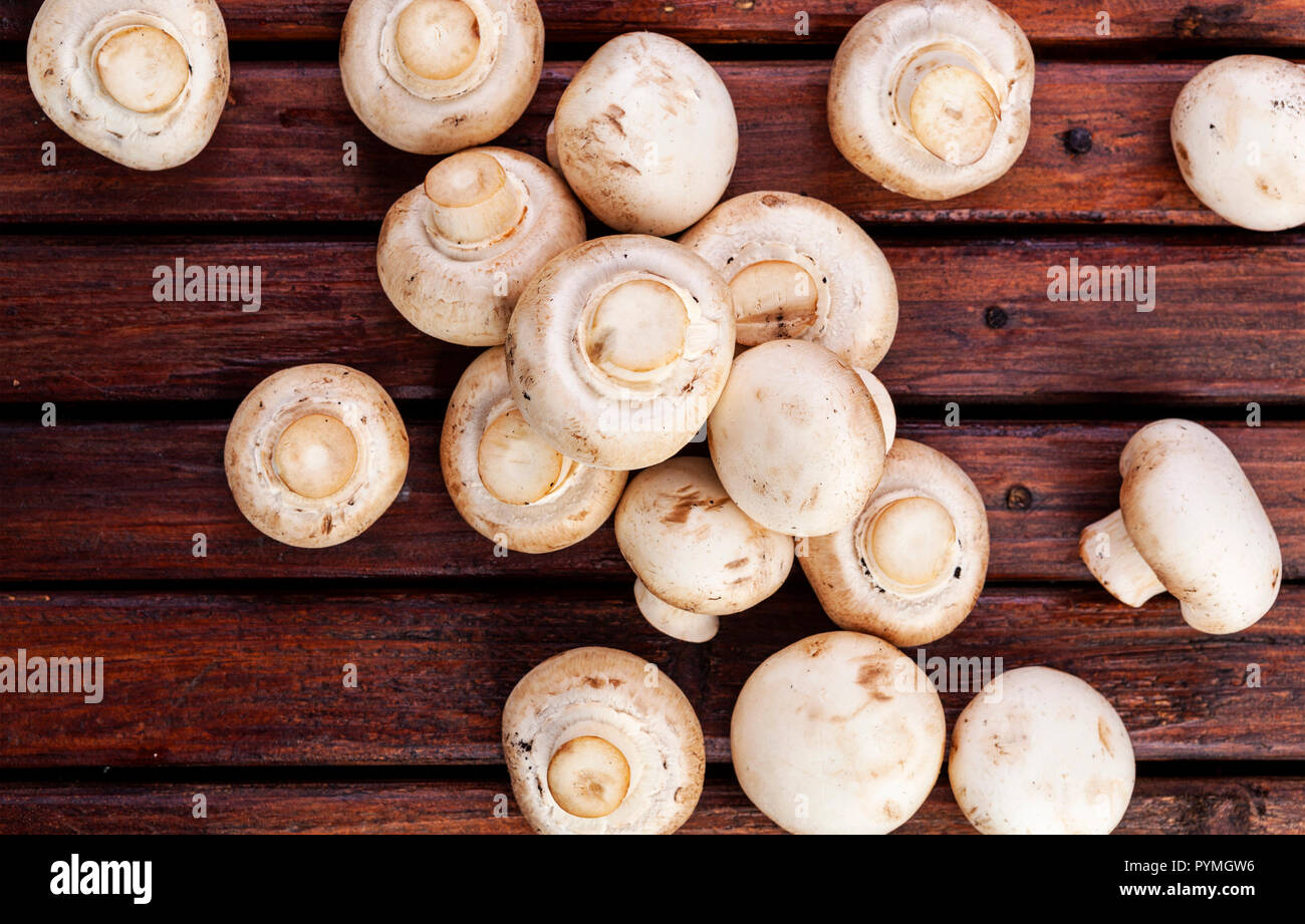 Fresh champignon mushrooms on wooden table, top view. Copy space Stock Photo