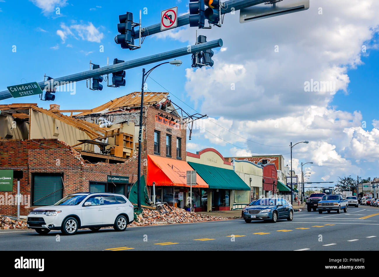 Cars drive past hurricane-damaged buildings on Lafayette Street after Hurricane Michael, Oct. 20, 2018, in Marianna, Florida. Stock Photo