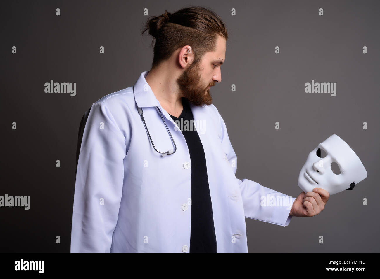 Young bearded man doctor against gray background Stock Photo