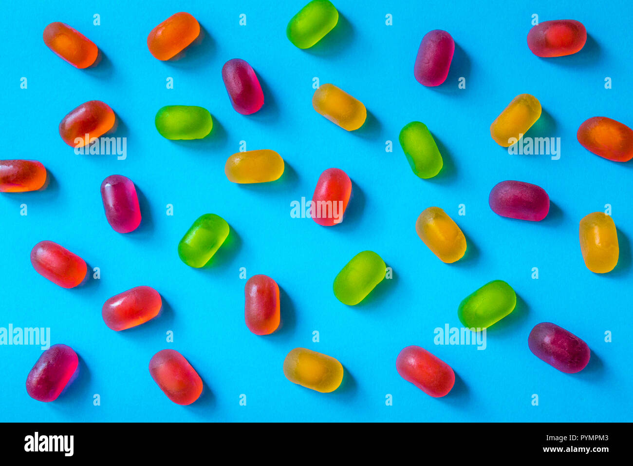 Colorful jelly candy pattern on a blue background, top view Stock Photo