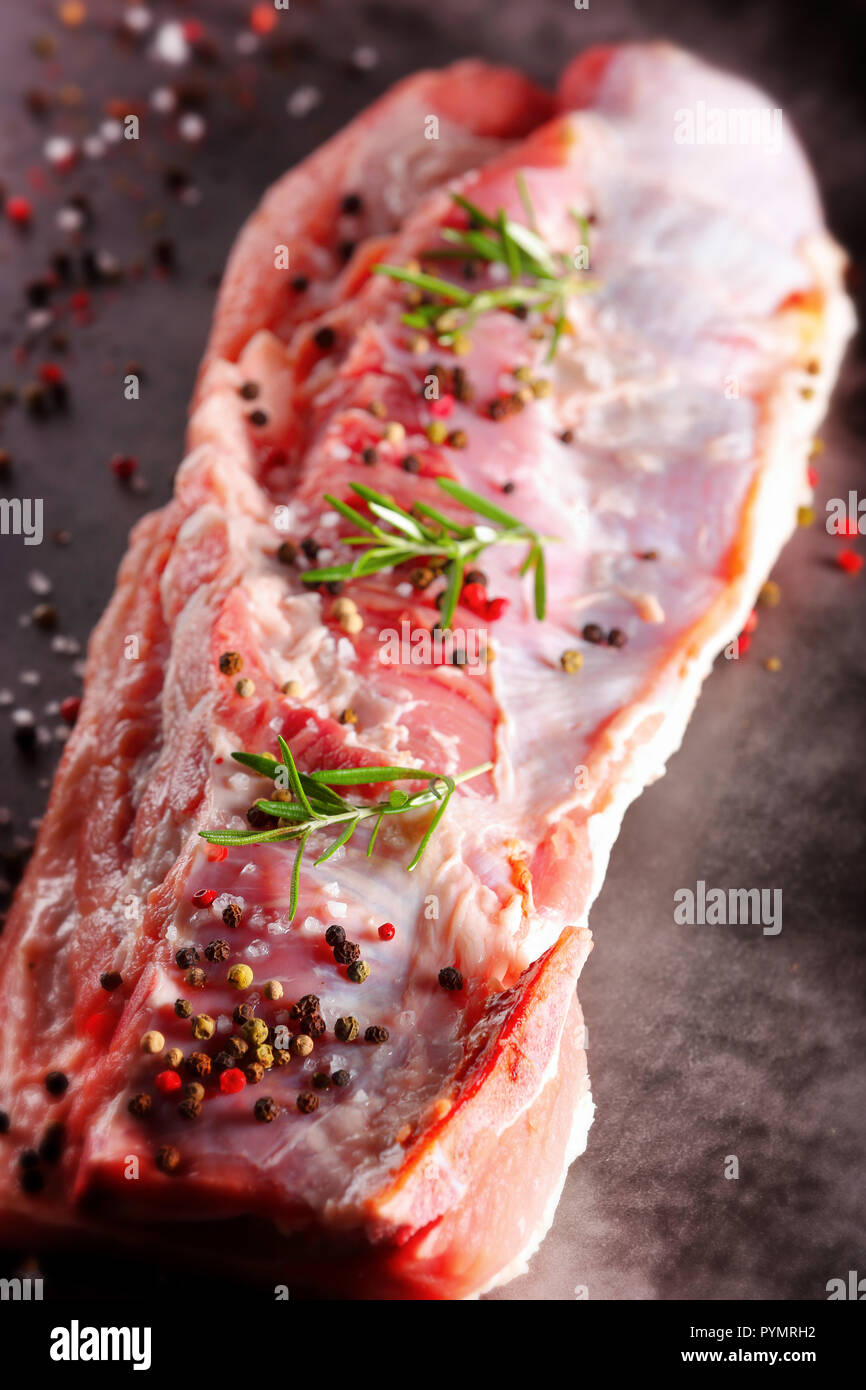 Raw ribs with spices on a stone background with empty space for text Stock Photo