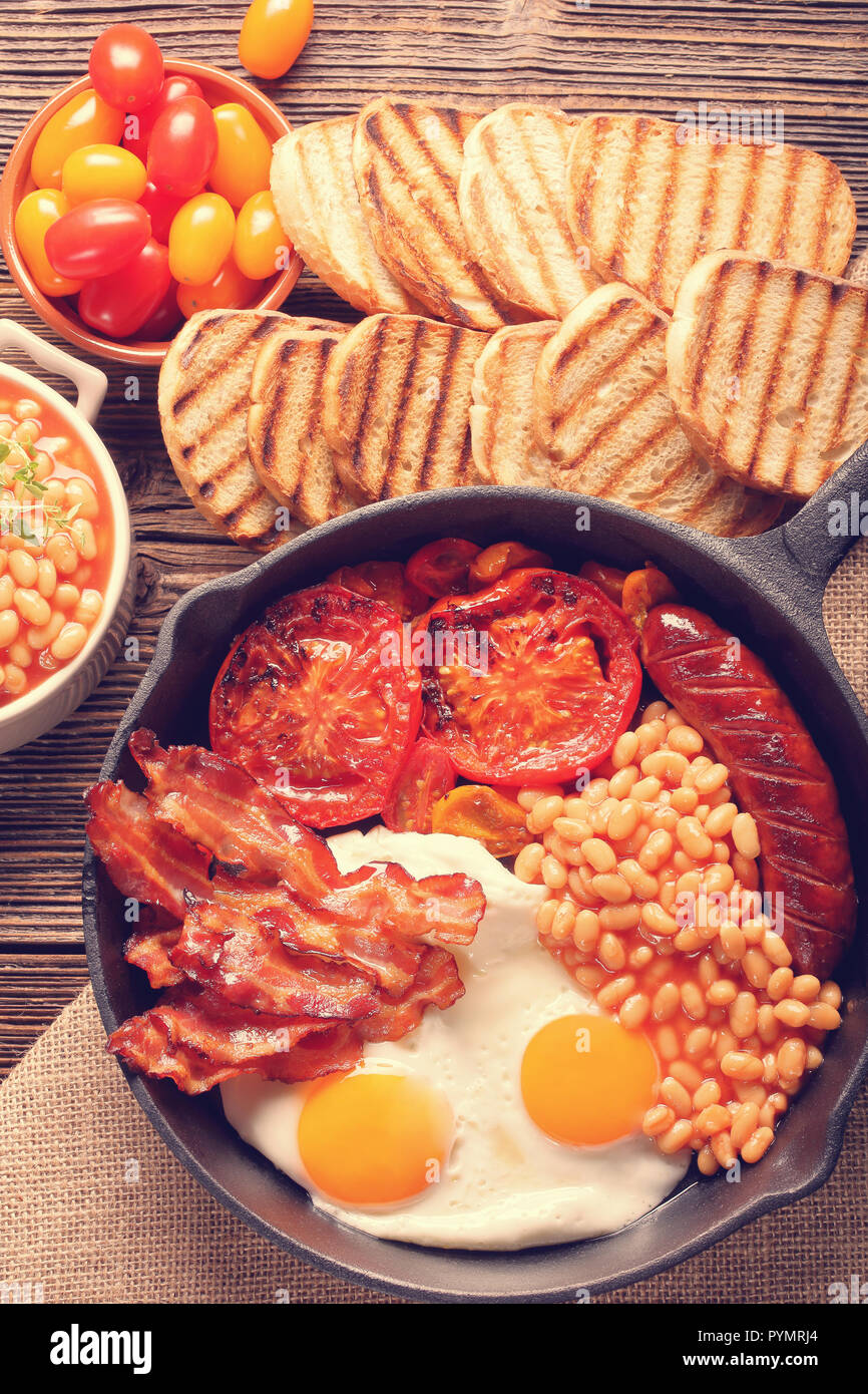 Traditional english breakfast food with eggs sausages bacon beans and ...