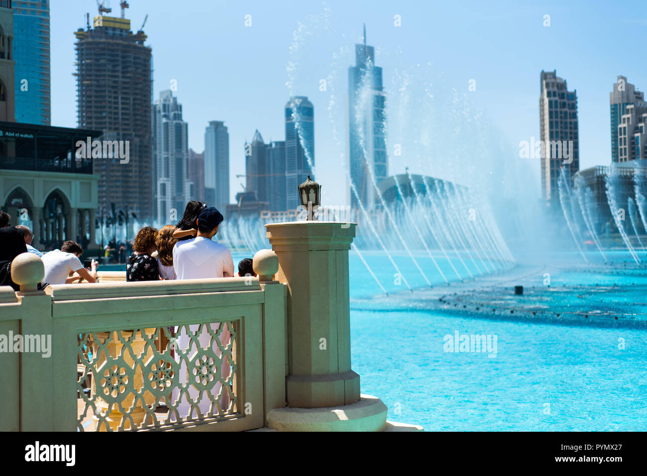 Dubai, United Arab Emirates - March 26, 2018: People gather around the Dubai mall fountain to see the water show which attracts many tourist every day Stock Photo