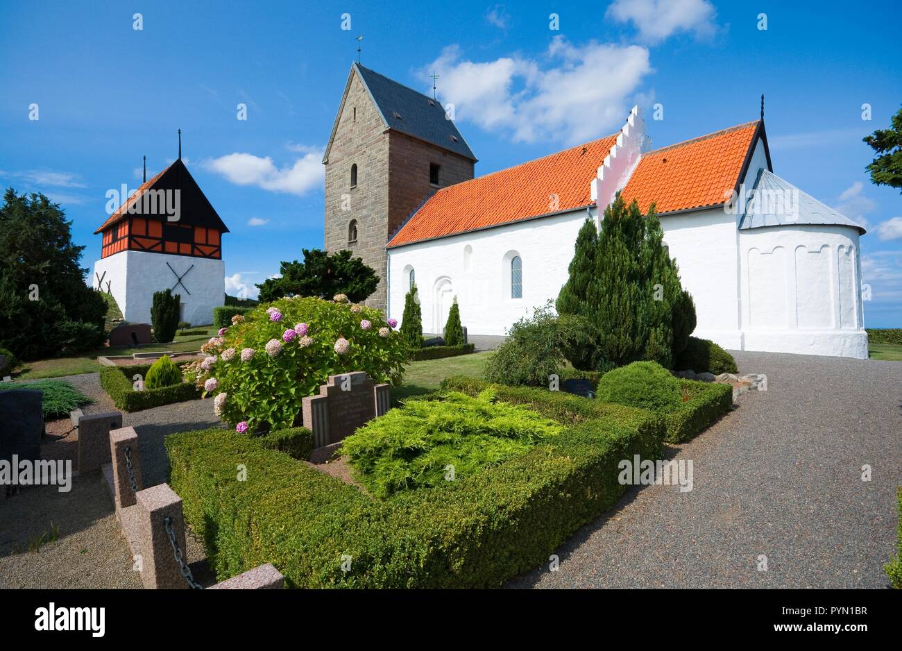 RUTSKER, DENMARK - AUGUST 25, 2018: View of the Church of Ruth from the graveyard. Built about 1200, is the highest point for a church anywhere in Den Stock Photo