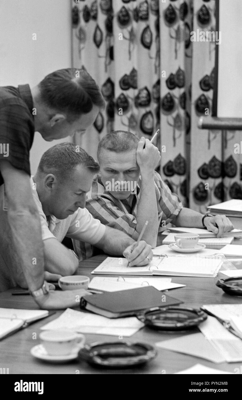 (2 Dec. 1965) --- Gemini-7 astronauts James Lovell Jr. (center) and Frank Borman (right) review mission requirements for their Gemini-7 flight. Stock Photo