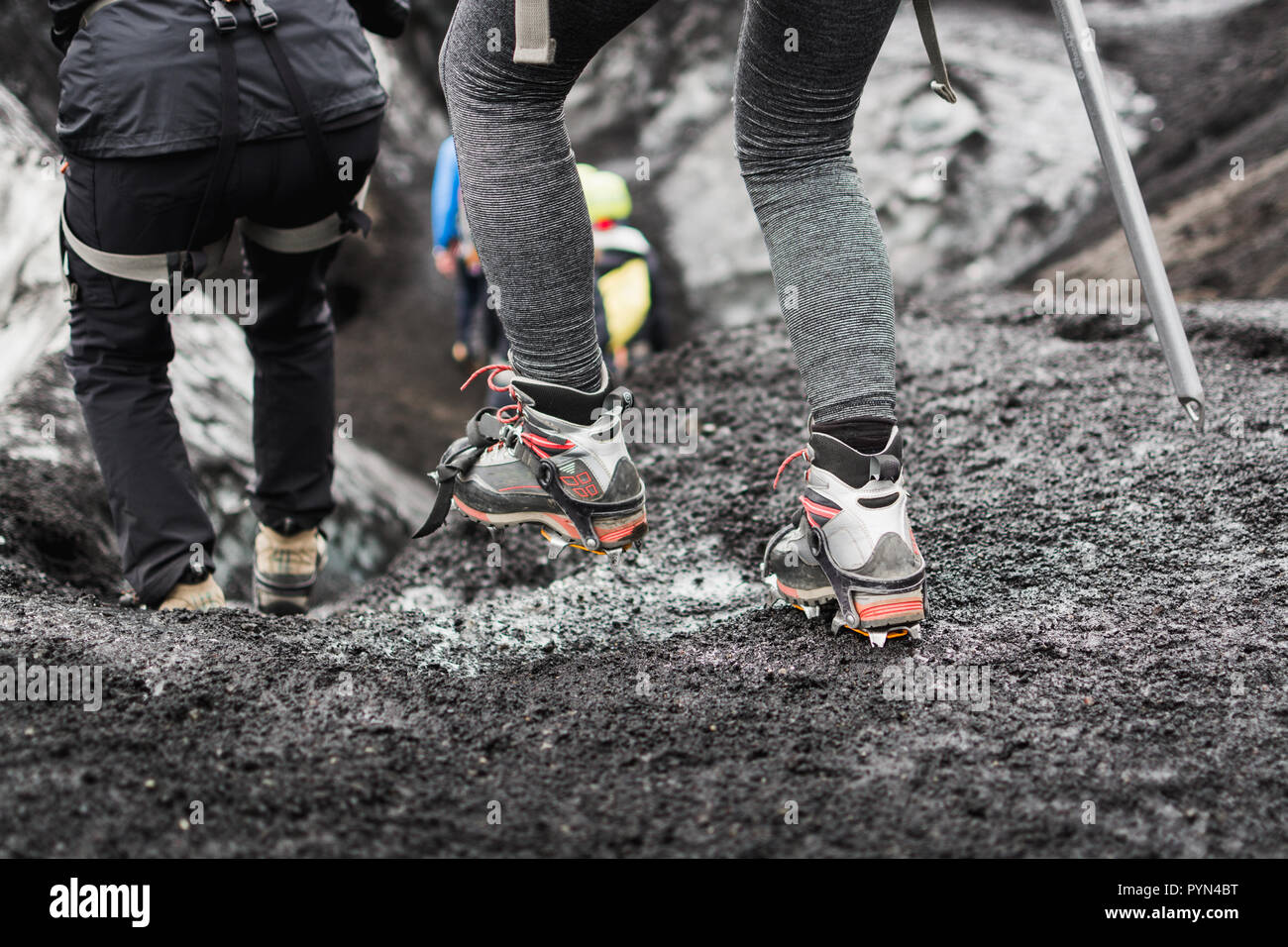 Group of tourists heading to the guided tour on the glacier, Iceland. Focus on special boots with crampons. Stock Photo