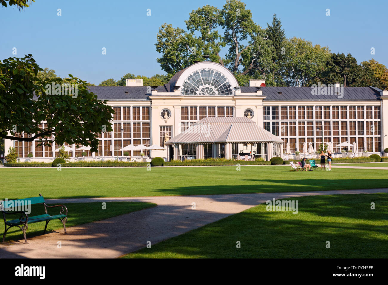 Warsaw, Poland - September 21, 2018: People resting at New Orangery in Lazienki Krolewskie park. Built in 1861 for the orange trees, it now houses the Stock Photo