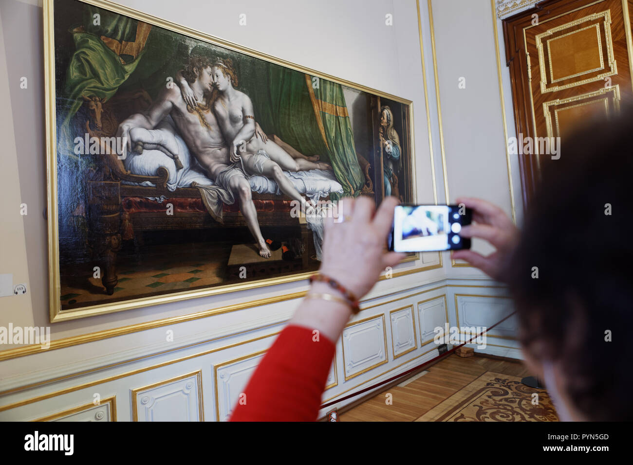 St. Petersburg, Russia - April 05, 2018: Chinese tourist make photo of the painting Love Scene of Julio Romano (1499-1546) in State Hermitage Museum Stock Photo