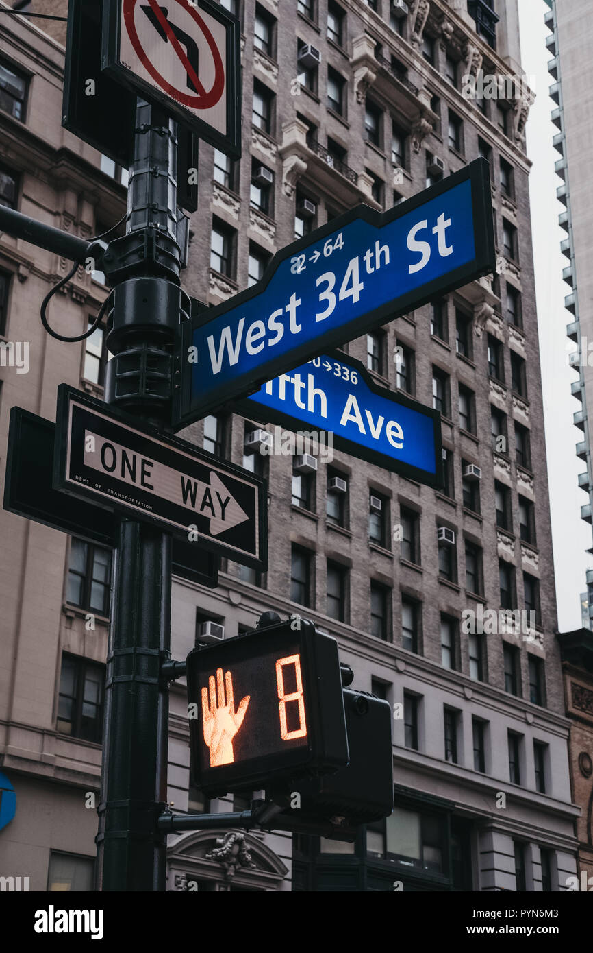 Street name and road signs on a lamp post on the corner Fifth Avenue