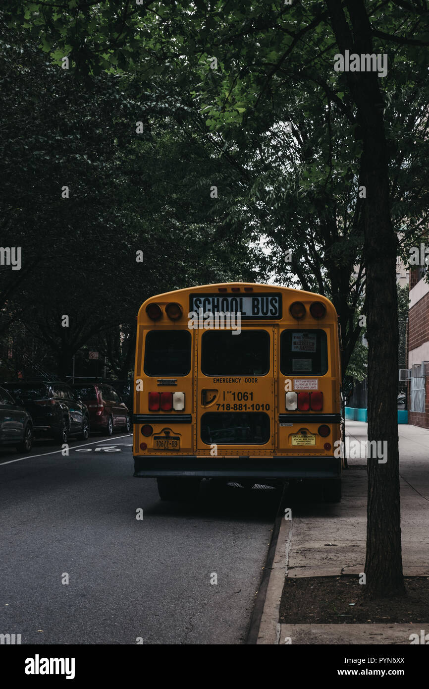 New York, USA - May 30, 2018: Yellow school bus parked on a side of the road in New York. The City of New York provides student with free transportati Stock Photo