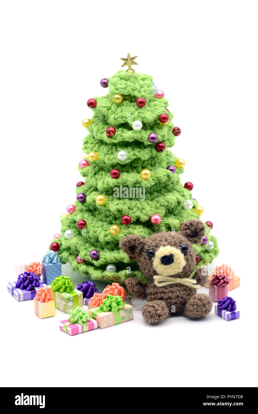 crochet christmas tree with pearls on white isolated background. Gifts under the tree. Stock Photo