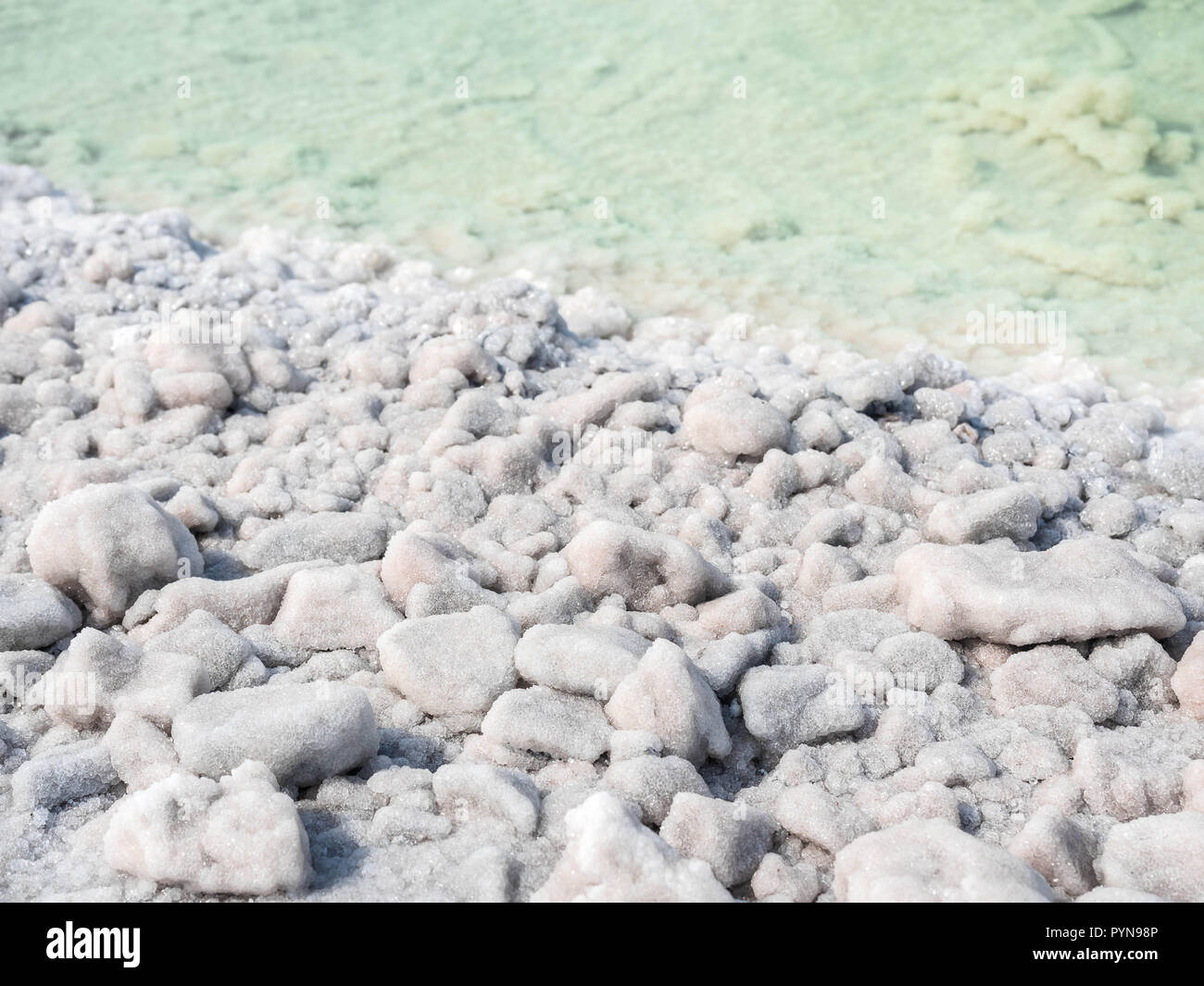 The stones are covered with a crust of salt on the shores of the salar Baskunchak Extraction of salt. Stock Photo