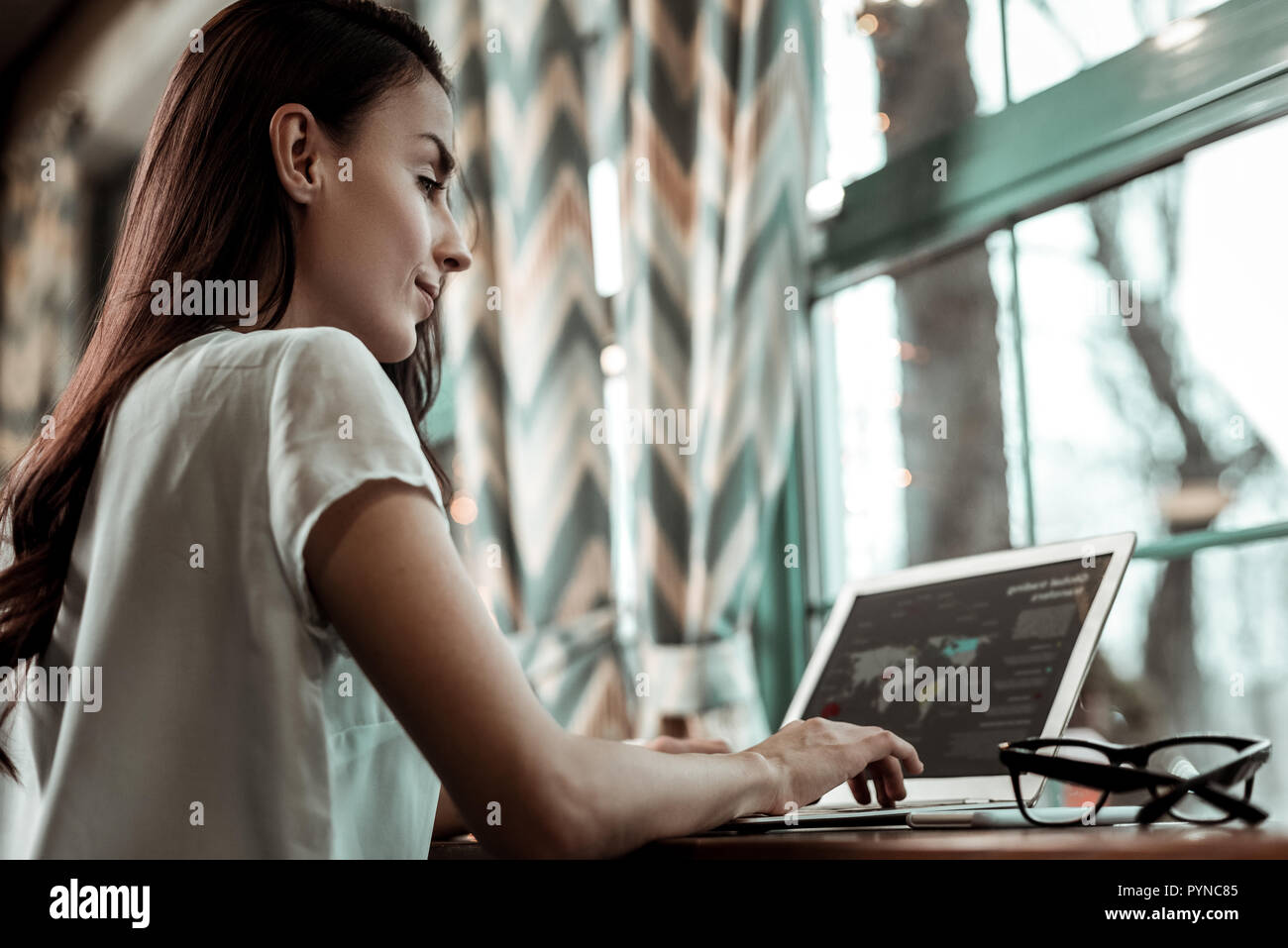 Concentrated female person looking at screen of her laptop Stock Photo