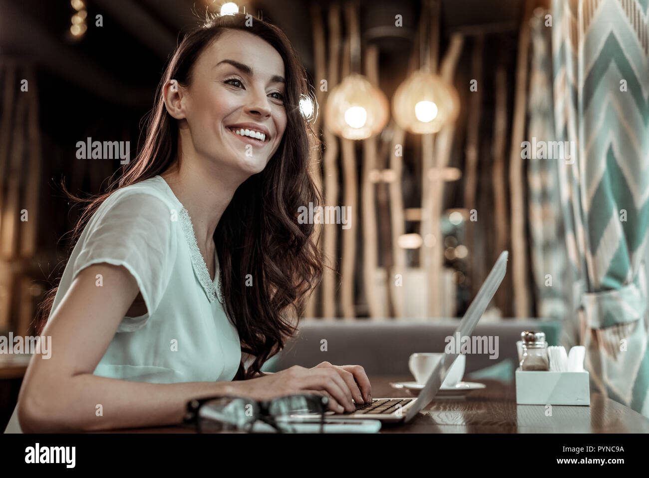 Pretty young woman keeping her hands on keyboard Stock Photo