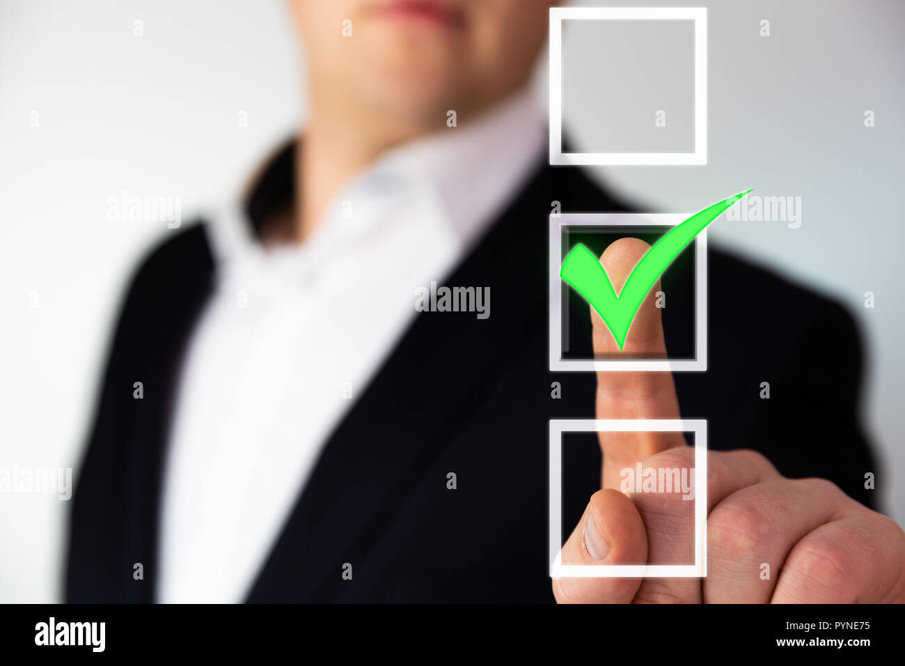 Businessman pushing checkbox button with a green tick. Stock Photo