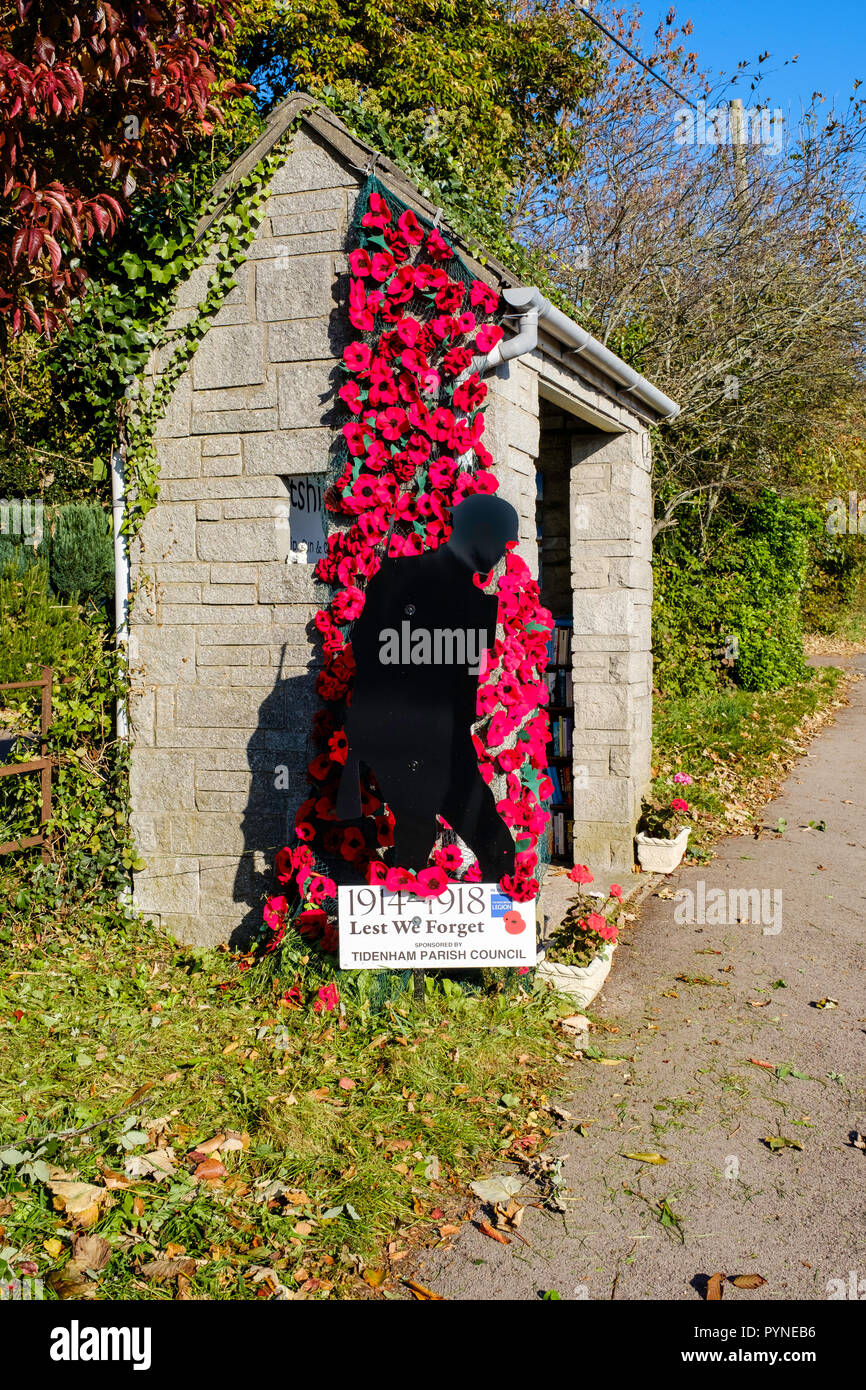Small bus shelter with figure of Silent Soldier against background of red poppies. They have been erected by Tidenham Parish Council and Tutshill WI. Stock Photo