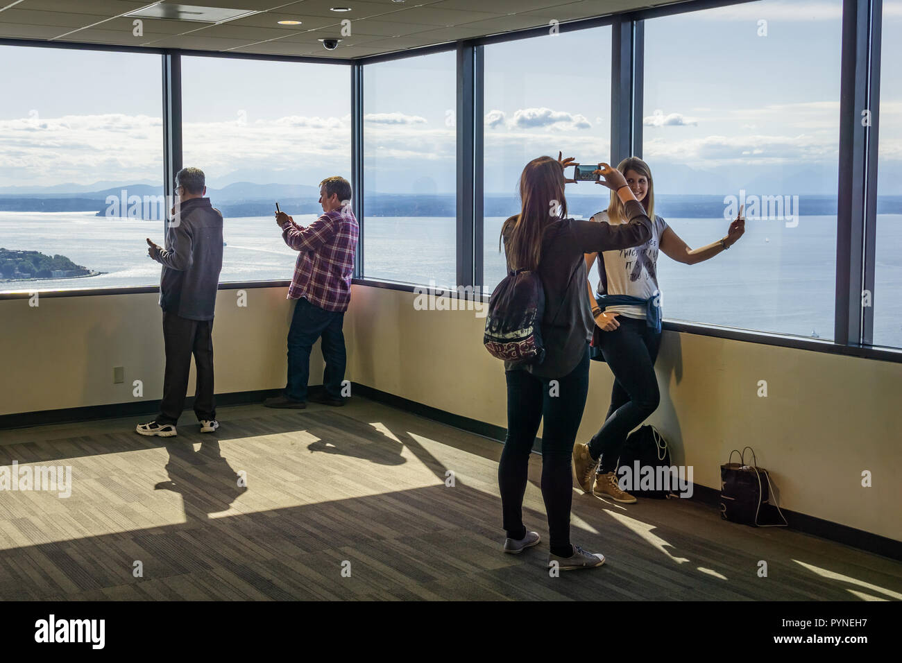 People at the Sky View Observatory Tower, Columbia Center, looking at Seattle cityscape and taking pictures, WA, USA. Stock Photo
