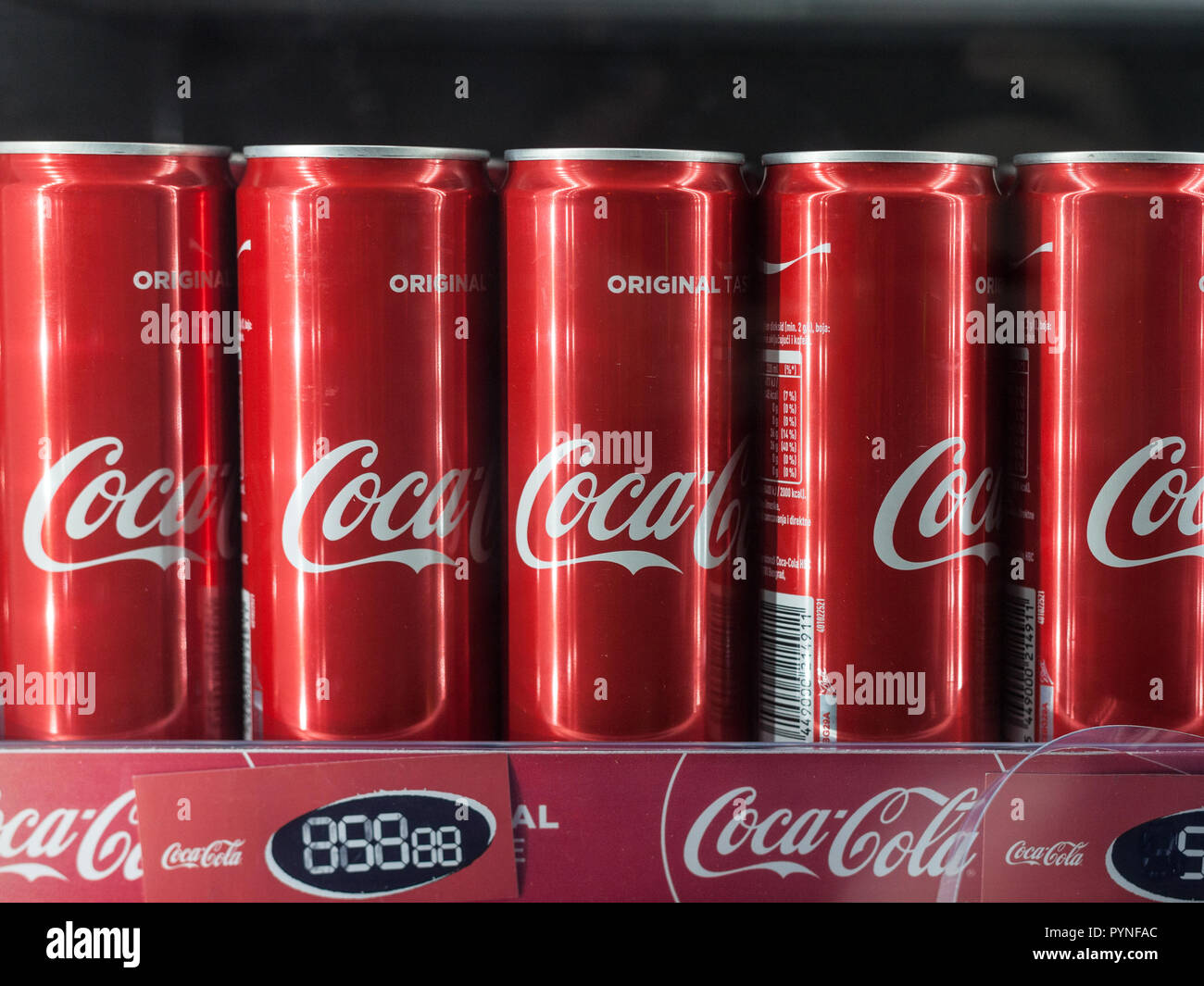 BELGRADE, SERBIA - OCTOBER 28, 2018: Coca Cola logo on cans aligned on the shelf of a fridge. Coca Cola is a soda brand of cola, the most sold in the  Stock Photo