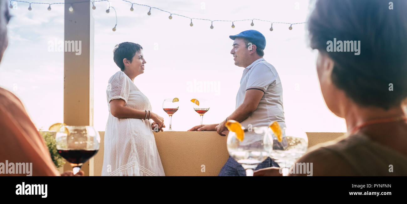 Couple first date drinking cup of red wine cocktail on the terrace at the bar. panoramic composition for caucasian people enjoying love and partnershi Stock Photo