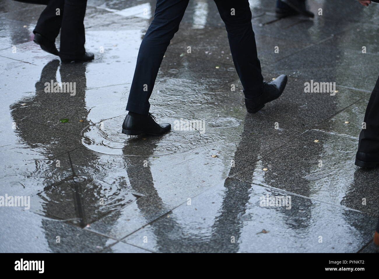 Rain and wind for commuters walking to work near Euston today. Picture Jeremy Selwyn Stock Photo