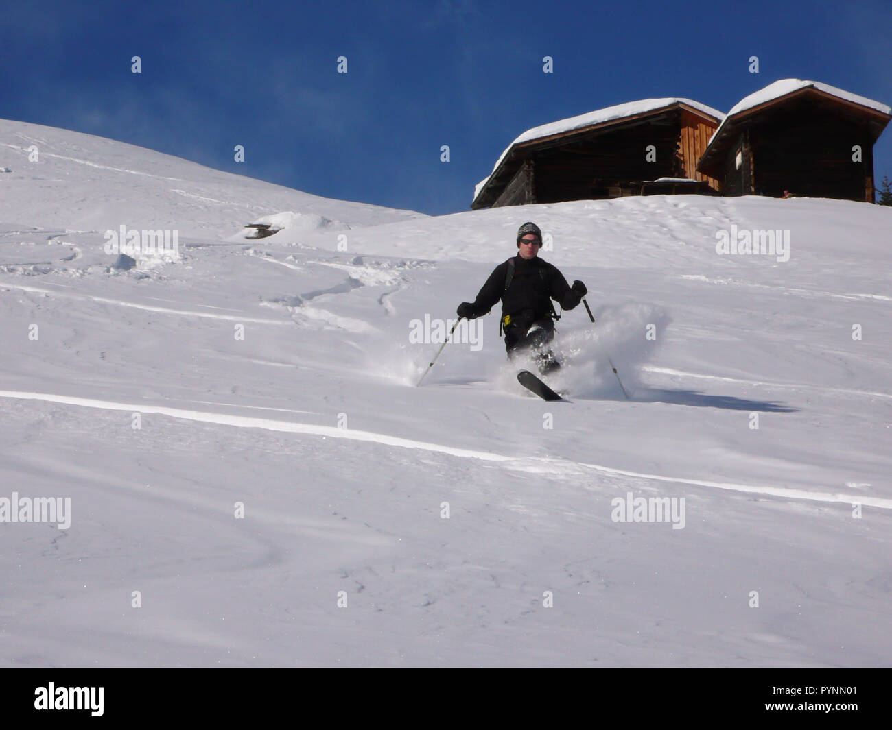 man telemark skiing in the Swiss backcountry in deep winter and fresh