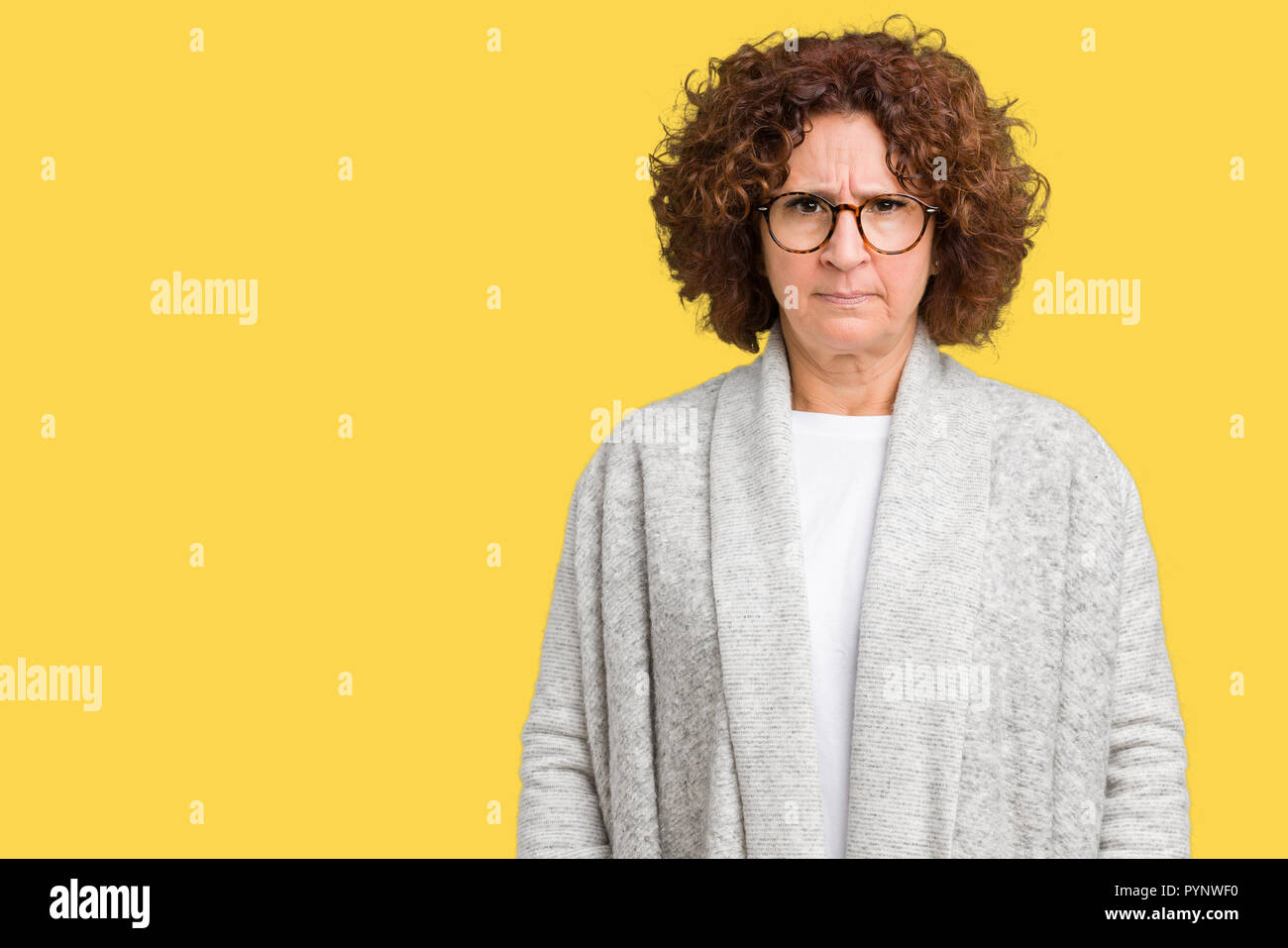 Beautiful middle ager senior woman wearing jacket and glasses over isolated background skeptic and nervous, frowning upset because of problem. Negativ Stock Photo