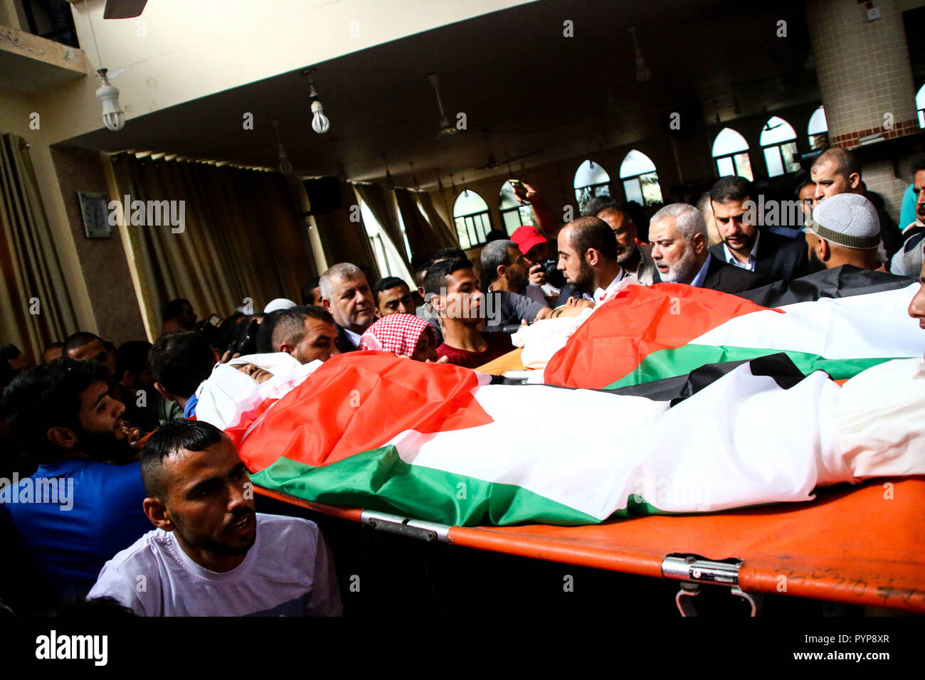 October 29, 2018 - The funeral of three boys killed last night by an Israeli airstrike close to the fence dividing Gaza and Israel takes place in the Al-Hikma mosque in the Deir Al-Balah city, in the central Gaza strip on 29 October 2018. The head of Hamas political bureau, Ismail Haniyeh, the senior member of the political bureau of the Islamic Jihad, Khaled al-Batsh, and the deputy speaker of the Palestinian Legislative Council, Ahmed Bahr, attended the ceremony at the mosque. Khaled Bassam Mahmoud Abu Saeed, 14, Abdul Hameed Mohammed Abdul Aziz Abu Zaher, 13, and Mohammed Ibrahim Abdullah A Stock Photo