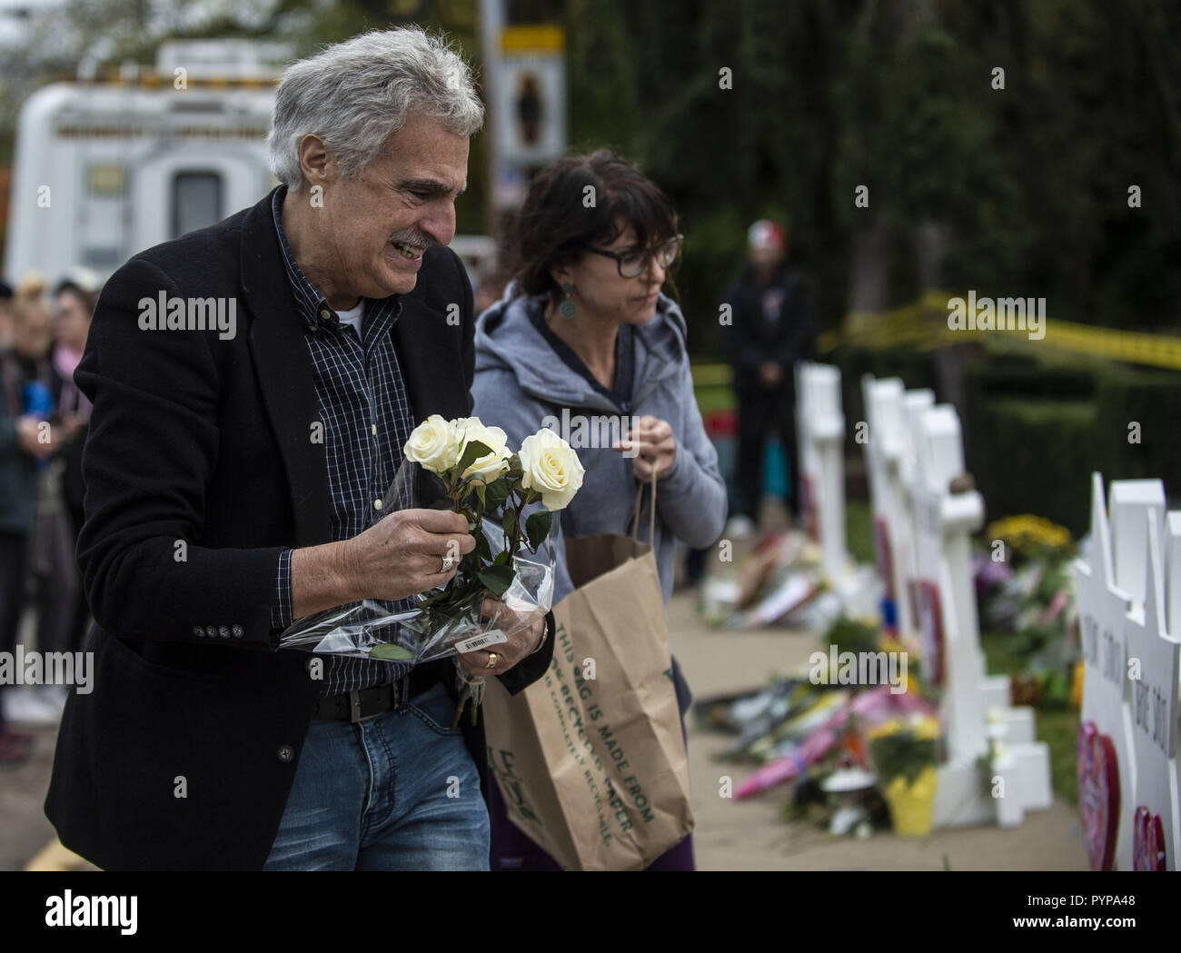 Pittsburgh, Pennsylvania, USA. 29th Oct, 2018. A mourner seen placing flowers on the memorials erected outside of the Tree of Life Synagogue in Squirrel Hill. Members of Pittsburgh and the Squirrel Hill community pay their respects at the memorial to the 11 victims of the Tree of Life Synagogue massacre perpetrated by suspect Robert Bowers on Saturday, October 27. Credit: Matthew Hatcher/SOPA Images/ZUMA Wire/Alamy Live News Stock Photo