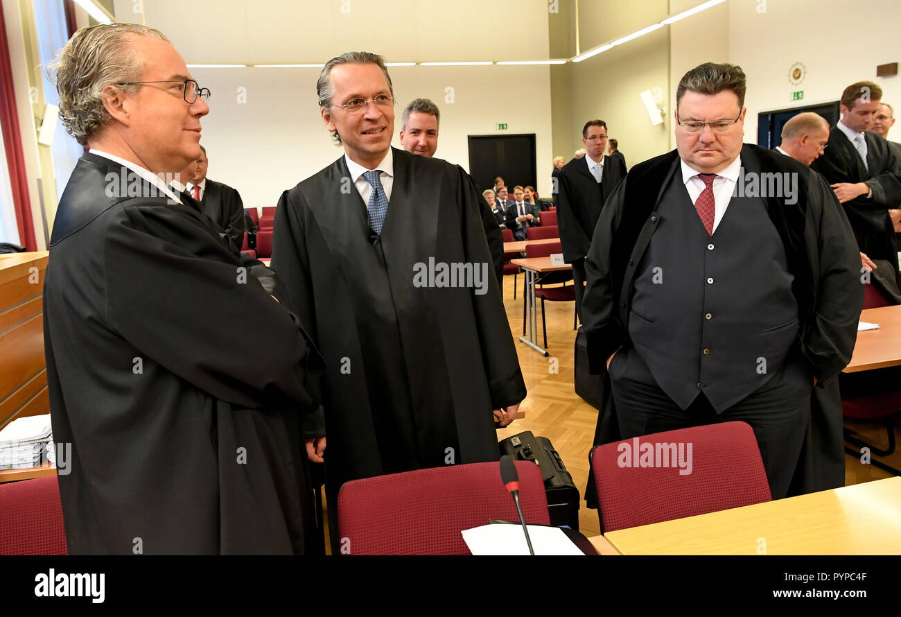 30 October 2018, Lower Saxony, Hannover: The lawyers Josef Broich (l-r), Albert W. Adametz and Andreas Tilp, representing the plaintiffs, are standing in a courtroom of the Regional Court at the beginning of the trial. In the takeover battle between VW and today's VW parent company Porsche SE in 2008, investors lost a lot of money. The plaintiffs are seeking damages from Porsche SE and Volkswagen AG for allegedly incorrect and misleading capital market information in connection with the acquisition of shares in Volkswagen AG. (to dpa 'Sample proceedings for the takeover battle VW/Porsche will Stock Photo