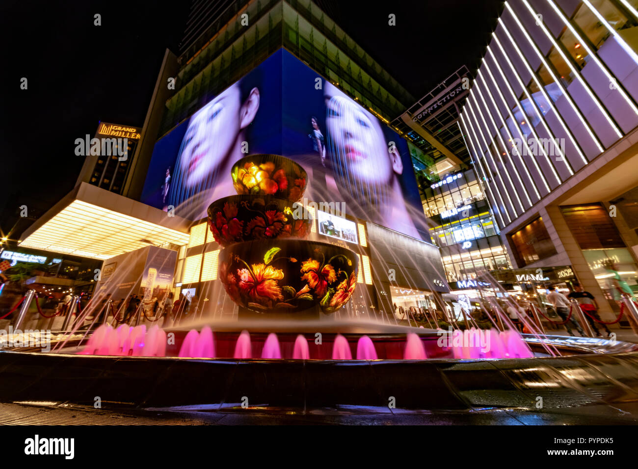 KUALA LUMPUR, 16 August 2018 - colorful fountain in front of the busy and crowded 'Pavilion' shopping mall of the city at night Stock Photo