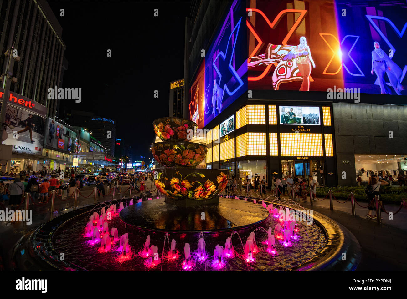 KUALA LUMPUR, 16 August 2018 - colorful fountain in front of the busy and crowded 'Pavilion' shopping mall of the city at night Stock Photo