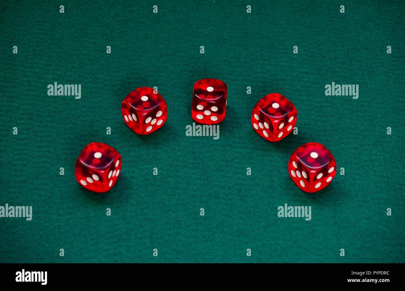 Several red dice with white dots on a green mat Stock Photo