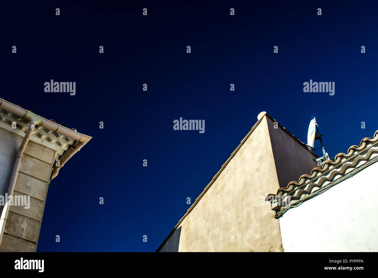 Abstract roof tops against a clear blue sky in Saintes Maries de la Mer Camargue France Stock Photo
