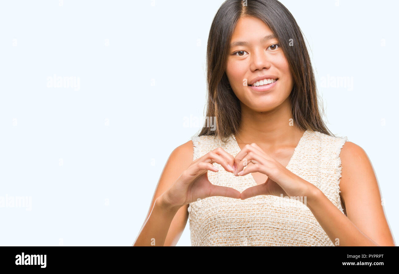 Young asian woman over isolated background smiling in love showing ...