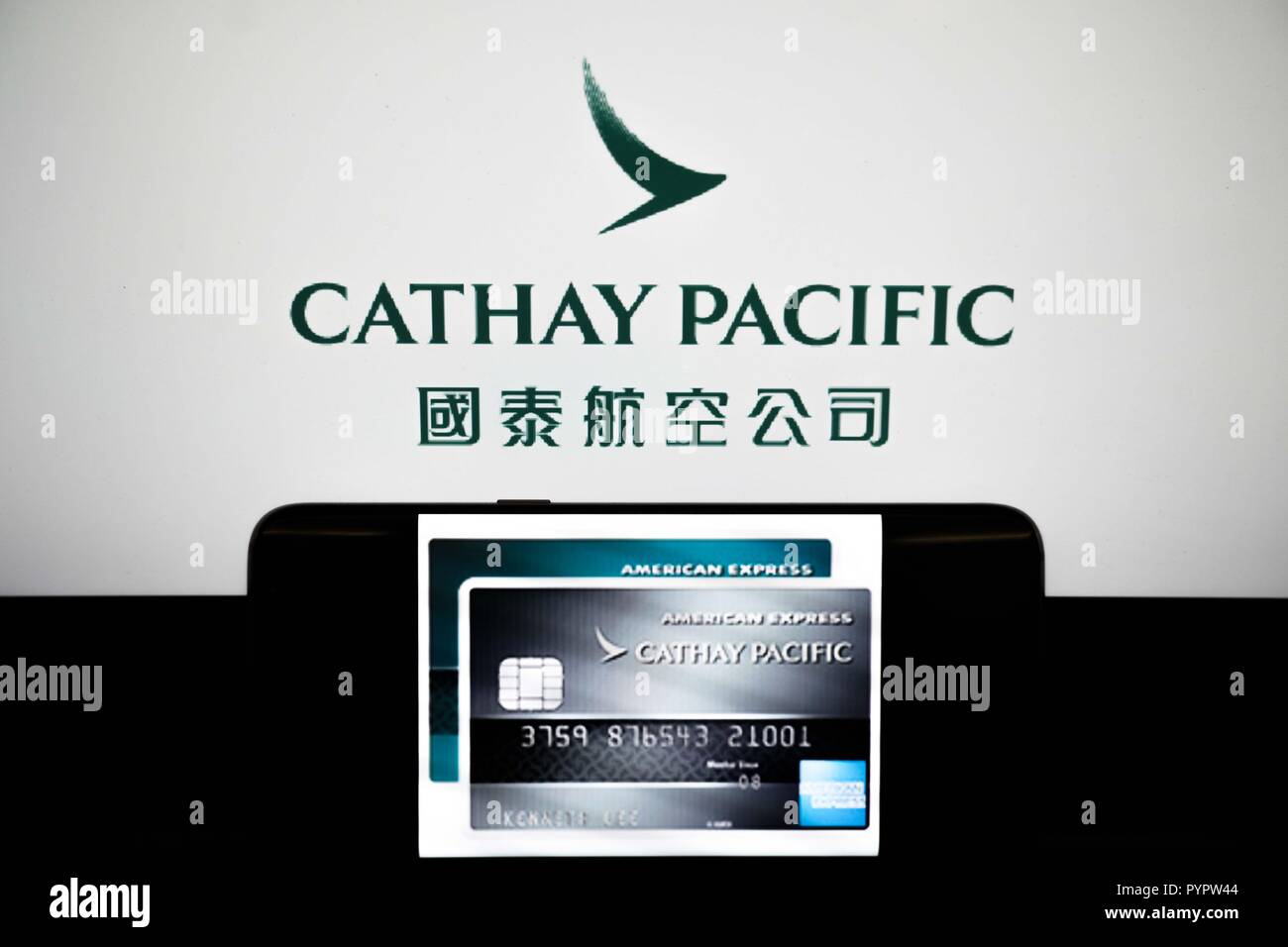 Cathay Pacific credit card displayed on a smartphone in front of a background of the Cathay Pacific logo. The Hong Kong based airline Cathay Pacific has reported that there has been a major data leak happened in march 2018 with data of around 9.4 million passengers was compromised during the breach, with 860,000 passport numbers, 245,000 Hong Kong identity card numbers, 403 expired credit card numbers and 27 credit card numbers without CVV being accessed. Stock Photo