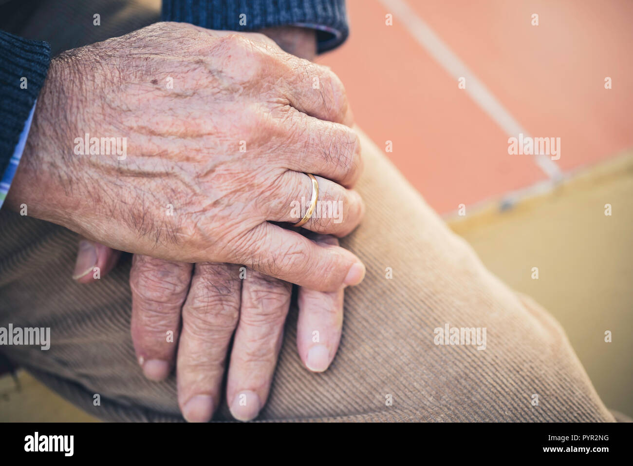 Elderly hand with ring resting on the other hand Stock Photo