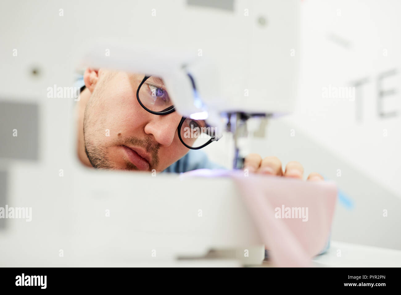 Concentrated tailor checking needle of sewing machine Stock Photo