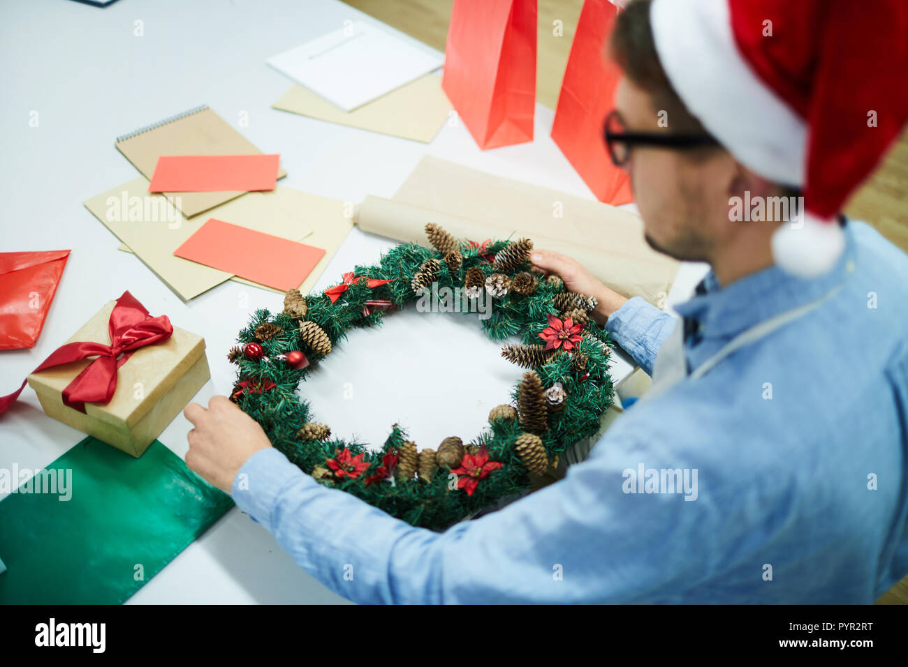 Busy man decorating Christmas wreath Stock Photo