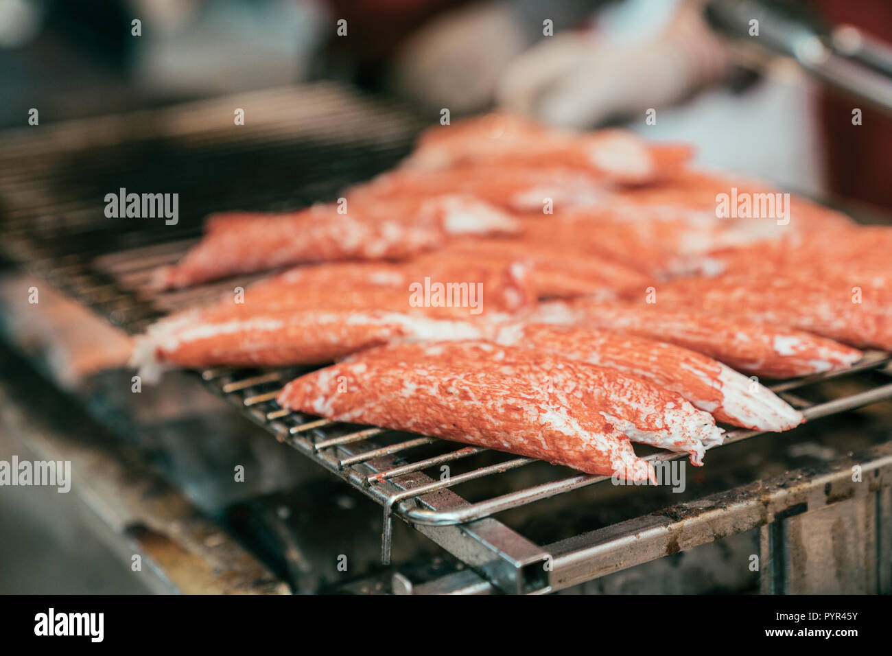 delicious japanese street food red crab. Clusters of fresh snow crab legs cooking on iron plate. hot grilled seafood in japan traditional market. Stock Photo